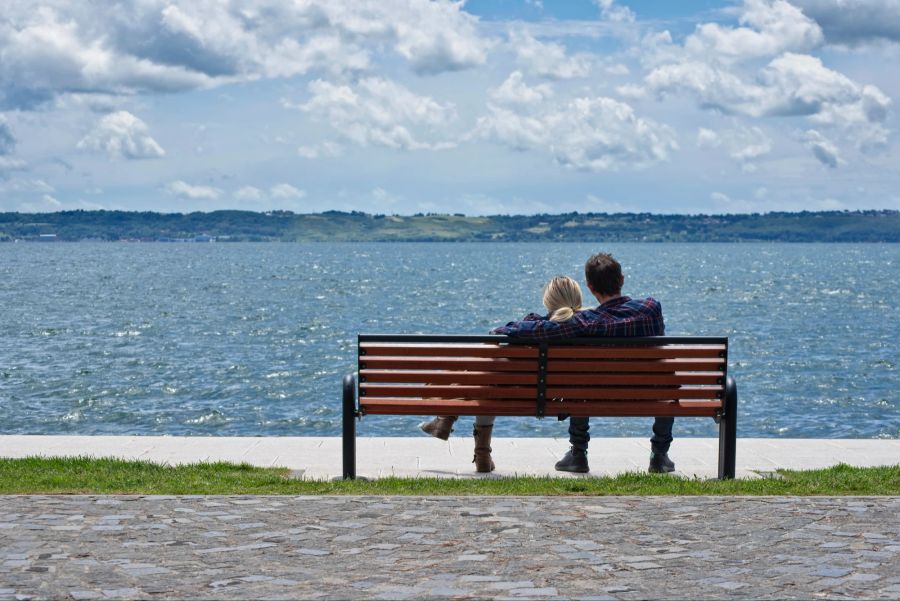 Paar am Wasser auf einer Bank