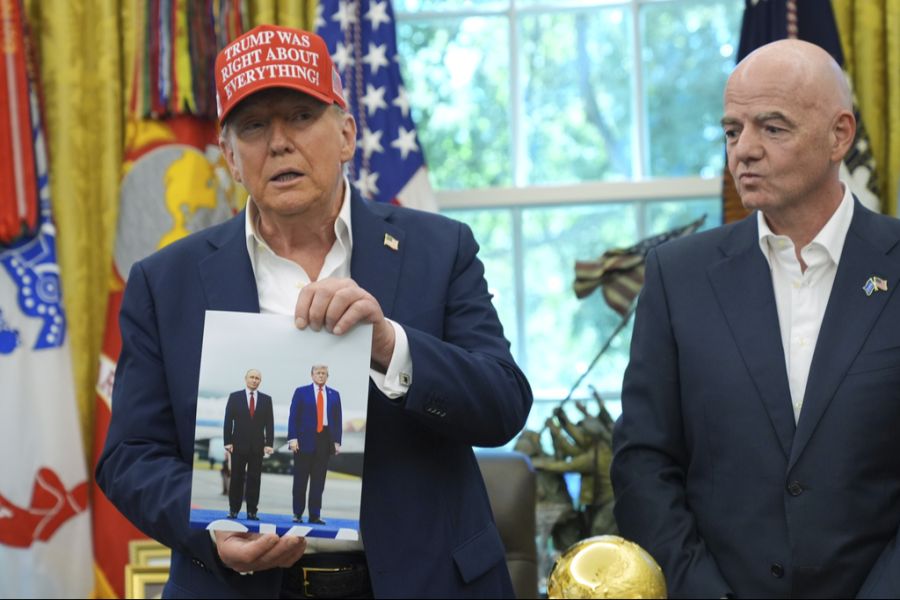 Plötzlich zeigte Trump dann ein Foto mit Putin, während Infantino daneben stand.