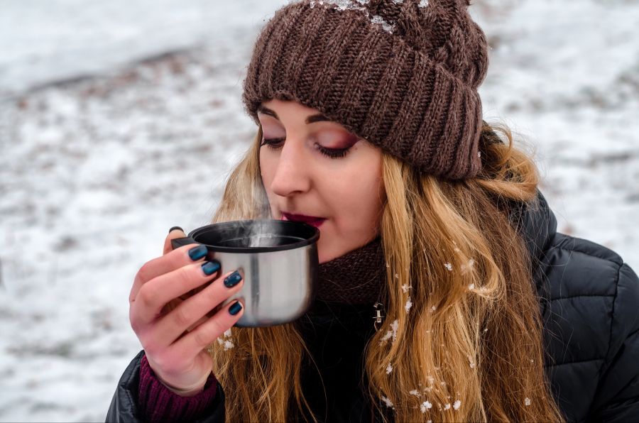 Frau trinkt Tee im Winter