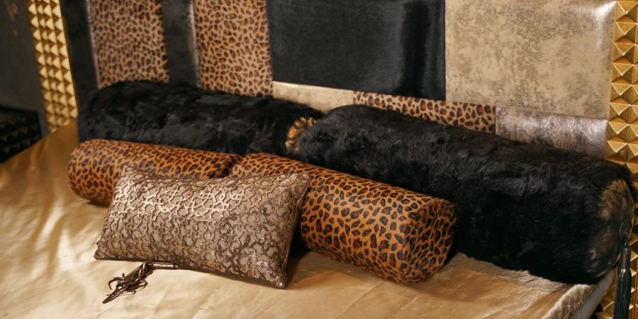 Leopard-Print-Kissen auf einem Bett.