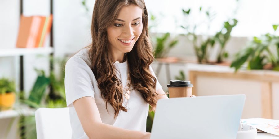 Lächelnde Frau sitzt in Ihrem Homeoffice