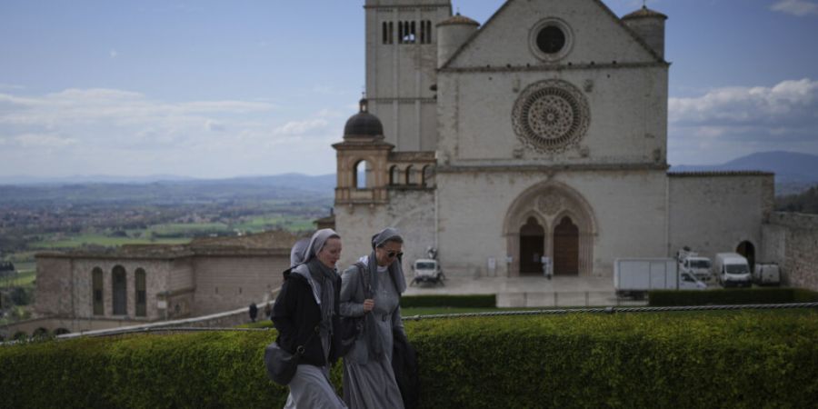 ARCHIV - Nonnen gehen an der päpstlichen Basilika und dem Kloster des Heiligen Franz von Assisi in Assisi vorbei. Foto: Alessandra Tarantino/AP/dpa