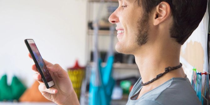 junger mann schaut auf smartphone