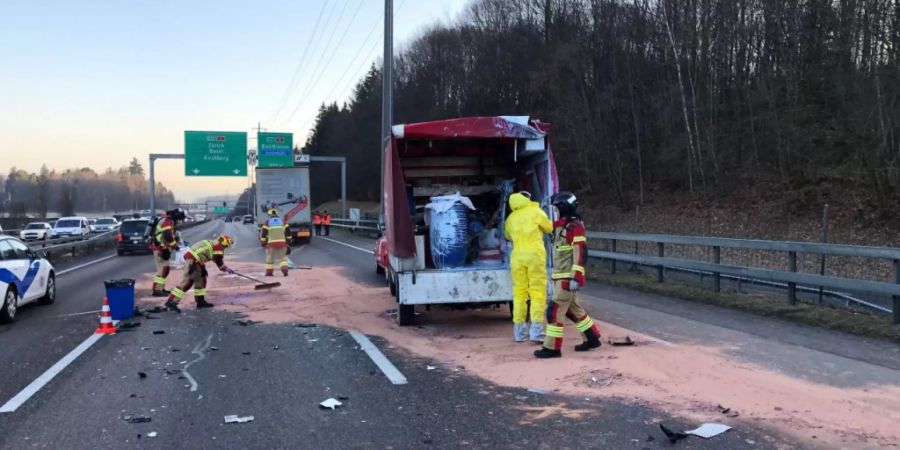 Feuerwehrleute beim Binden von flüssigem Kautschuk, das eines der verunfallten Fahrzeuge geladen hatte.