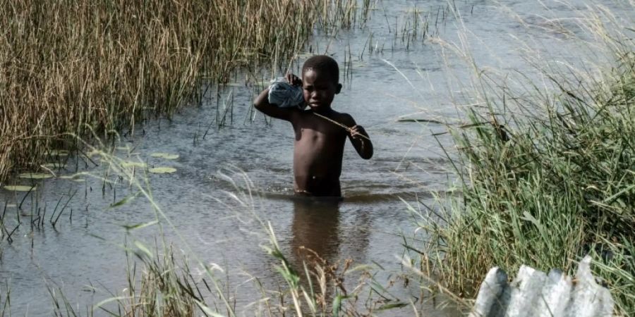 Junge watet durch Hochwasser in Beira
