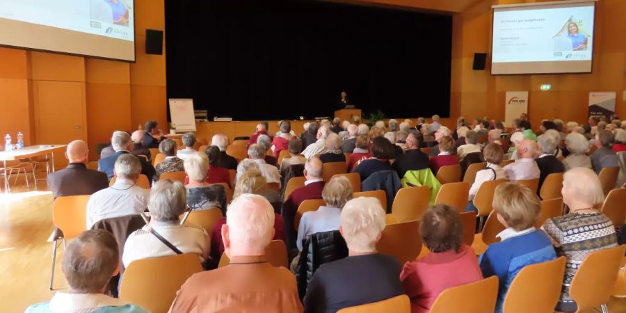 Senioren hören einen Vortrag in einem Saal