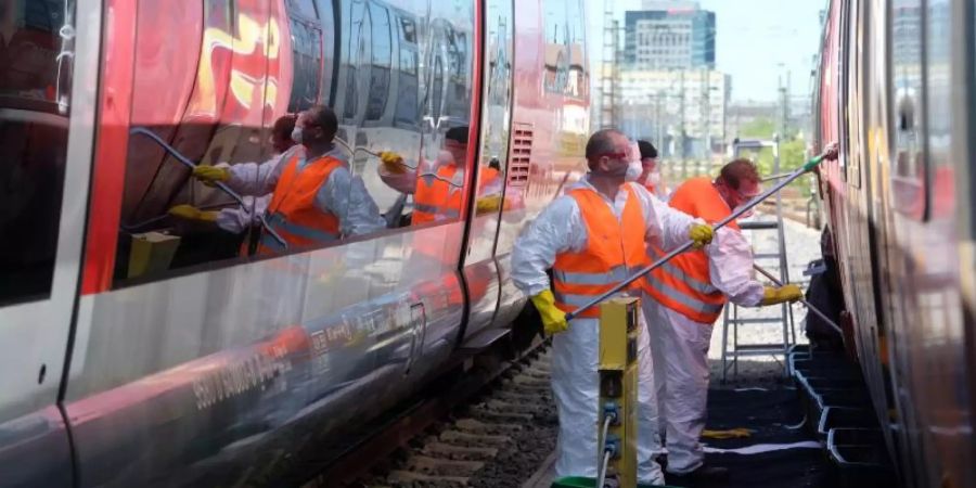 Graffiti-Entferner arbeiten am Leipziger Hauptbahnhof an besprühten S-Bahnwagen. Foto: Sebastian Willnow