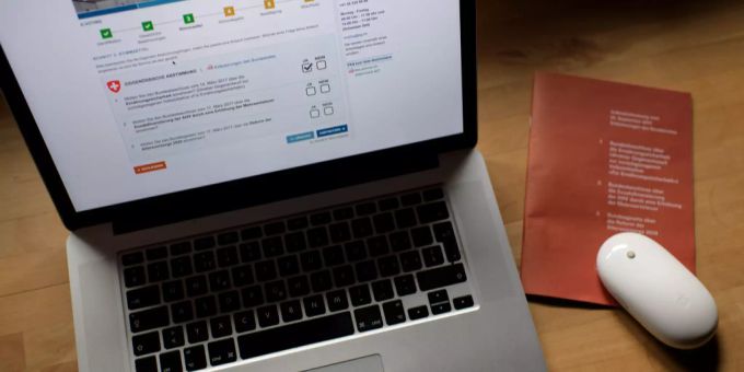 Blick auf die E-Voting Plattform des Kantons St. Gallen, die seit 2017 für Auslandschweizer sowie erstmals auch für die Stimmberechtigten in fünf ausgewählten Gemeinden zur Verfügung steht. Das Angebot soll schrittweise auf den ganzen Kanton ausgebaut werden. Laptop mit Abstimmungsbüchlein.
