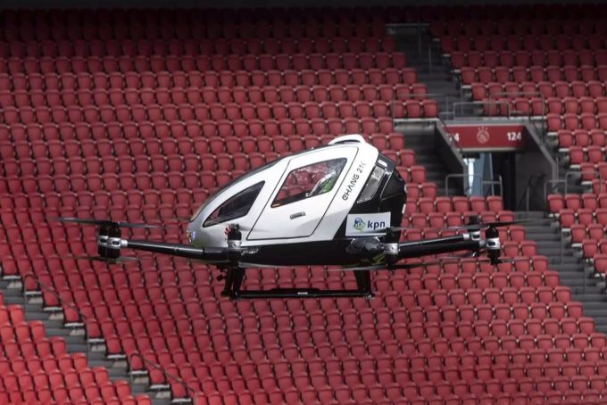 Ein Lufttaxi fliegt durch ein Stadion. Klimawandel Lufttaxi