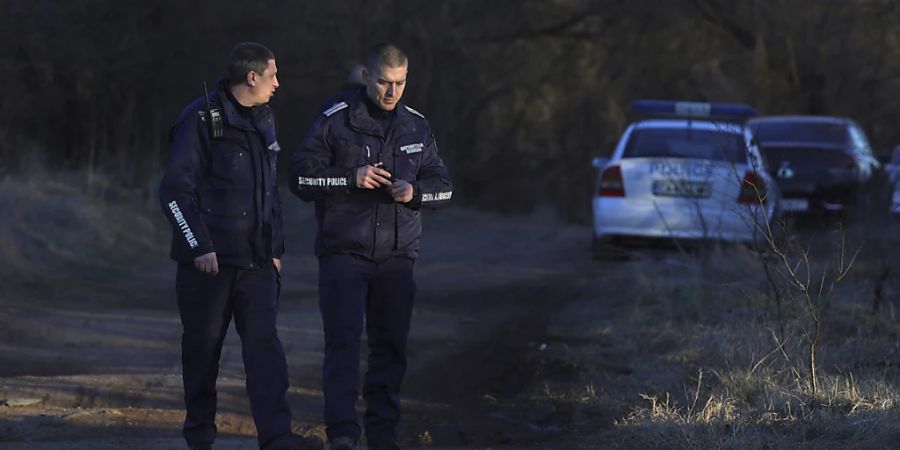 Bulgarische Polizeibeamte stehen an der Stelle, an der ein verlassener Lastwagen mit den Leichen von 18 Migranten gefunden wurde. Sie sind vermutlich erstickt. Die Personen wurden am Freitag nahe des westbulgarischen Dorfs Lokorsko tot aufgefunden, wie Medien in Sofia berichteten. Foto: Valentina Petrova/AP/dpa