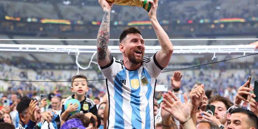 Argentiniens Lionel Messi lässt sich mit dem Weltmeisterpokal feiern.