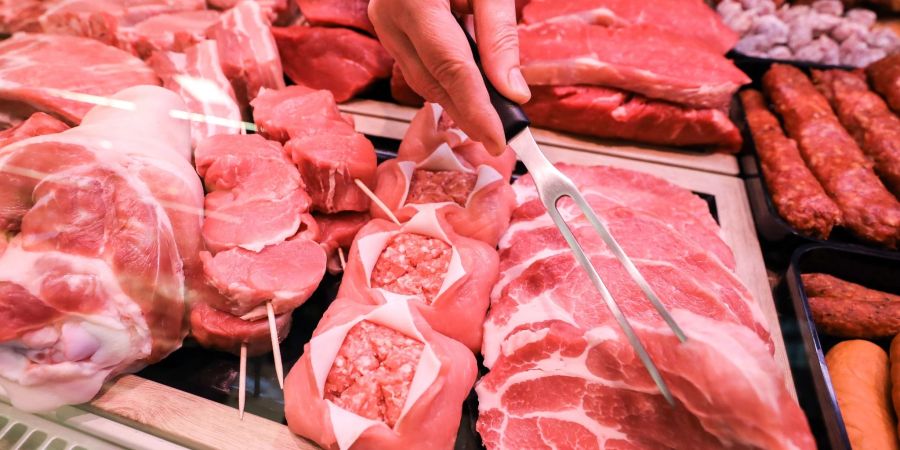 Verschiedene Sorten Schweinefleisch und Rindfleisch liegen in einer Fleischtheke in einem Supermarkt.
