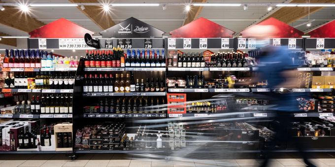 Ein Mann geht mit seinem Einkaufswagen in einem Discounter an Produkten vorbei. Ein Mann geht mit seinem Einkaufswagen in einem Discounter an Produkten vorbei.