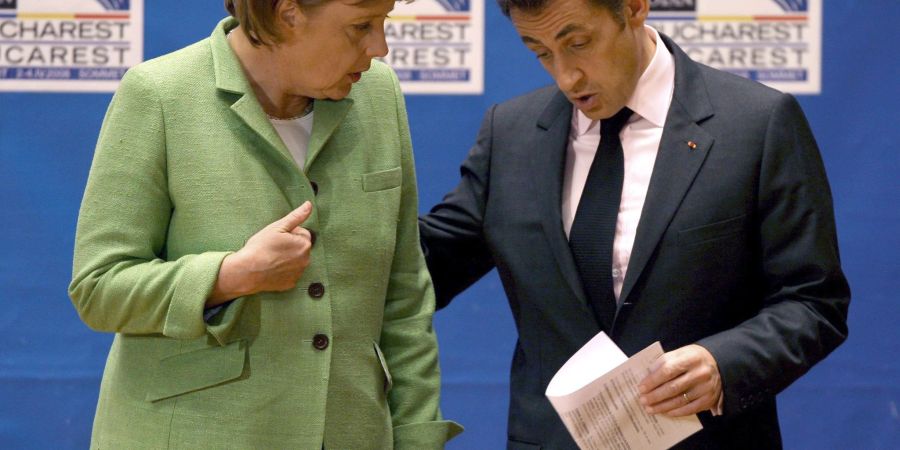 Die damalige Bundeskanzlerin Angela Merkel (l, CDU) spricht mit Nicolas Sarkozy, damals Präsident von Frankreich, am Ende der Eröffnungssitzung des NATO-Gipfels.