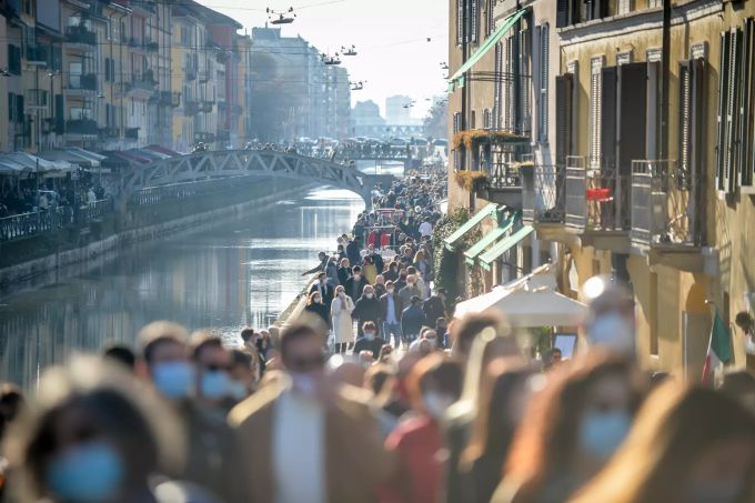 Menschen gehen bei schönem Wetter dicht gedrängt an einem der Kanäle in der Mailänder Innenstadt entlang. coronavirus mailand
