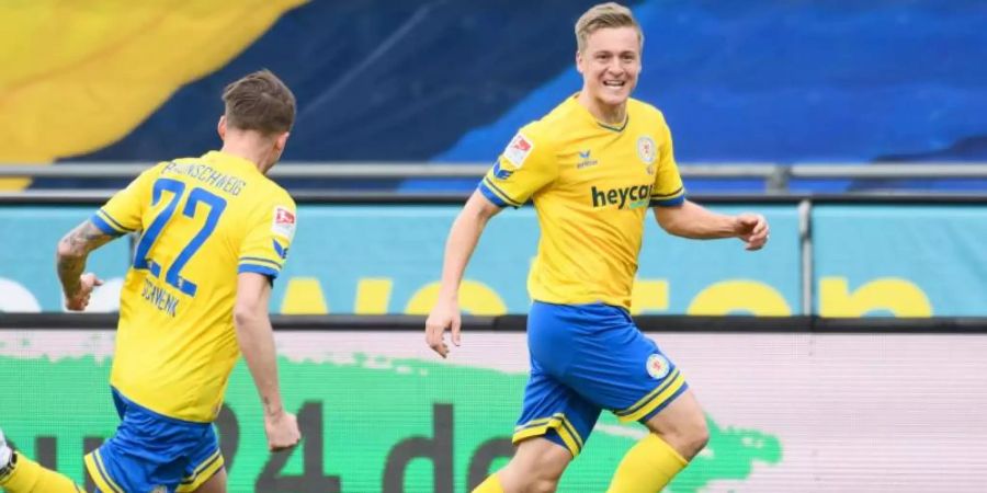 Braunschweigs Mittelfeldspieler Felix Kroos (r) jubelt mit Mannschaftskamerad Manuel Schwenk nach seinem Freistosstor zum späten 1:0. Foto: Swen Pförtner/dpa