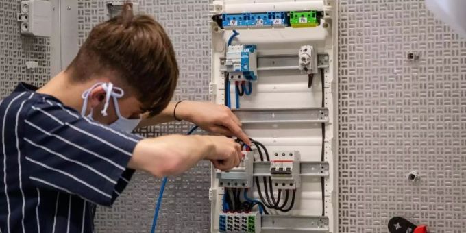 Ein Auszubildender arbeitet in einer Werkstatt. azubi