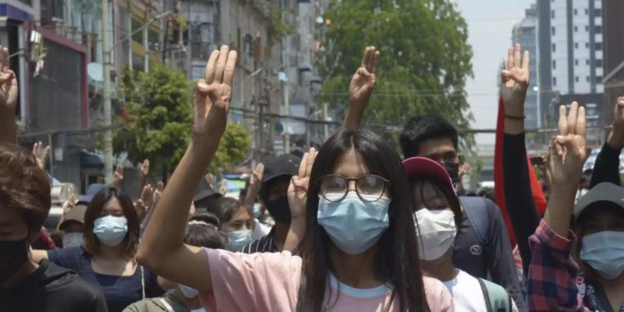 Anti-Putsch-Demonstranten zeigen während eines Protests in Rangun gegen die Militärregierung den Drei-Finger-Gruss als Zeichen des Protests. Foto: Uncredited/AP/dpa