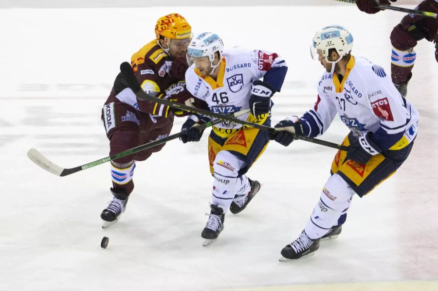 Servette-Topscorer Henrik Tömmernes (l.) versucht, Zugs Lino Martschini (m.) von der Scheibe zu trennen.