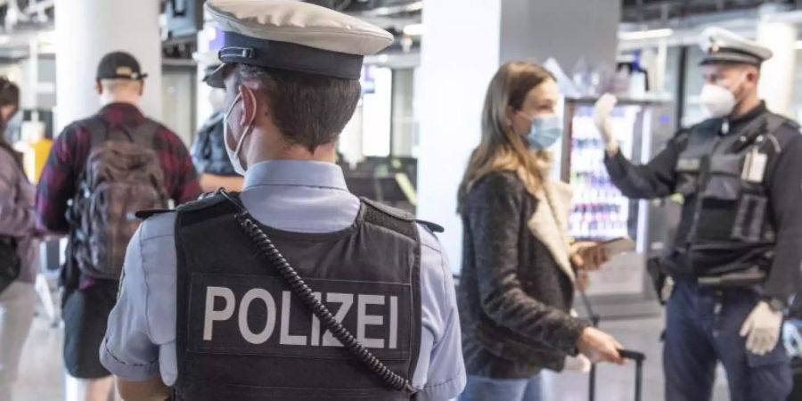 Die Bundespolizei kontrolliert Reisende am Frankfurter Flughafen. Foto: Boris Roessler/dpa