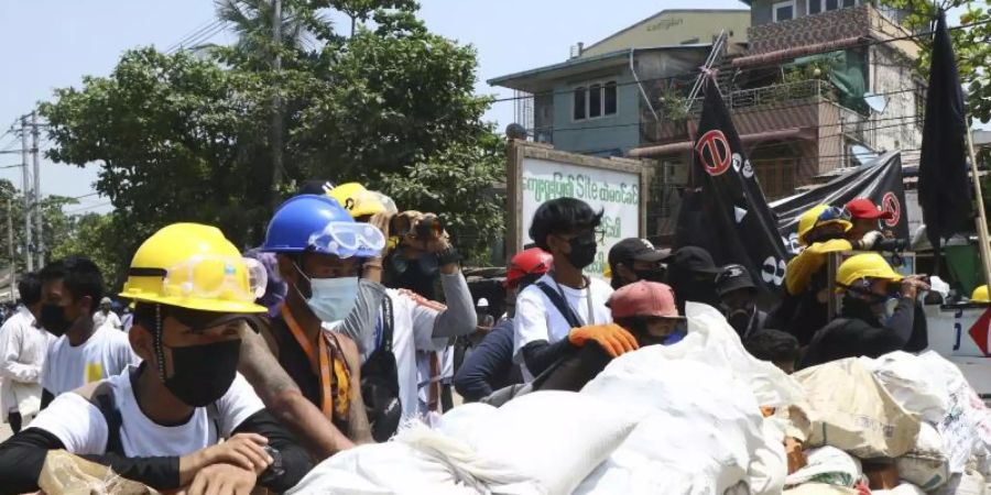 Demonstranten bereiten im Stadtteil Tarkata eine Barrikade vor. Die neue Junta in Myanmar geht weiter mit brutaler Gewalt und Inhaftierungen gegen politische Gegner, Demonstranten und Journalisten vor. Foto: -/AP/dpa