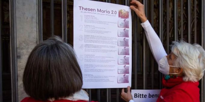 Zwei Aktivistinnen der katholischen Reforminitiative Maria 2.0 hängen ein Plakat mit ihren Thesen an das Hauptportal des Freiburger Münsters. Foto: Philipp von Ditfurth/dpa Zwei Aktivistinnen der katholischen Reforminitiative Maria 2.0 hängen ein Plakat mit ihren Thesen an das Hauptportal des Freiburger Münsters. Foto: Philipp von Ditfurth/dpa