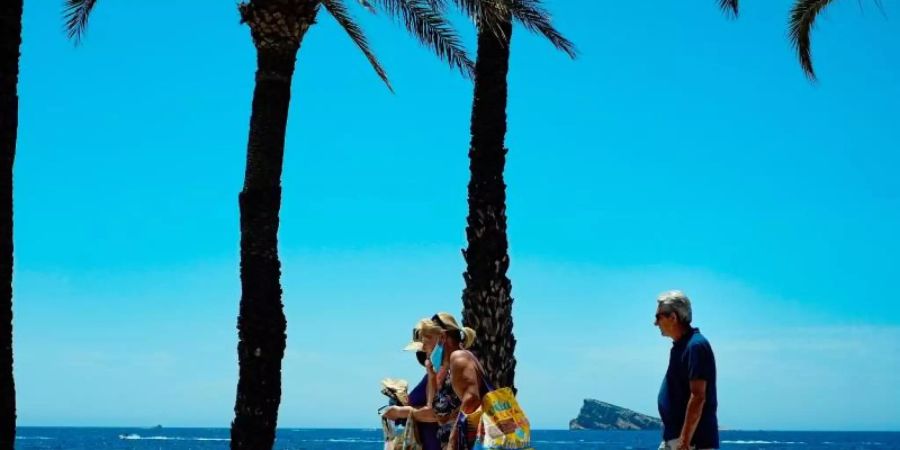 Menschen geniessen einen Sommertag am Strand im spanischen Benidorm. Wegen stark steigender Corona-Infektionszahlen stuft die Bundesregierung am Sonntag ganz Spanien als Risikogebiet ein. Foto: Alvaro Barrientos/AP/dpa