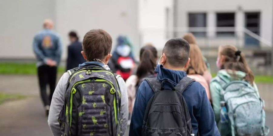 Schülerinnen und Schüler gehen zur Einschulung einer fünften Klasse zum Klassenzimmer. Foto: Sebastian Gollnow/dpa