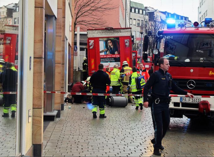 Einsatzkräfte von Feuerwehr und Rettungsdienst stehen in der Innenstadt am Einsatzort. Unfall Passau LKW Tote