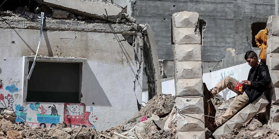 Ein junger Palästinenser steht nach Einsätzen der israelischen Armee im Lager Nur Shams in der Stadt Tulkarm inmitten von beschädigten Gebäuden. Foto: Ayman Nobani/dpa