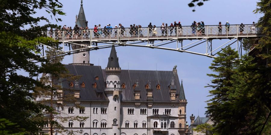 Touristen auf der Marienbrücke vor dem Schloss Neuschwanstein.