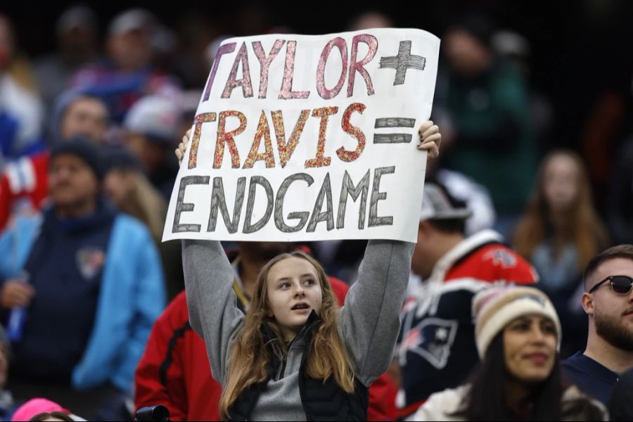 Ein Fan hält ein Schild hoch um auf Taylor Swift und Travis Kelce hinzuweisen, während dem Spiel der Kansas City Chiefs gegen die New England Patriots, am 17. Dezember 2023 in Foxborough, Ma