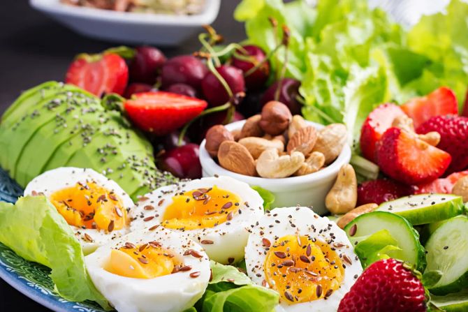 Teller mit Eiern, Obst, Gemüse, Nüssen