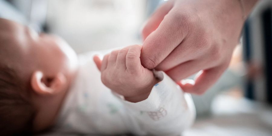 Ein Baby klammert sich an den Finger seiner Mutter. In Italien kommen immer weniger Babys zur Welt.