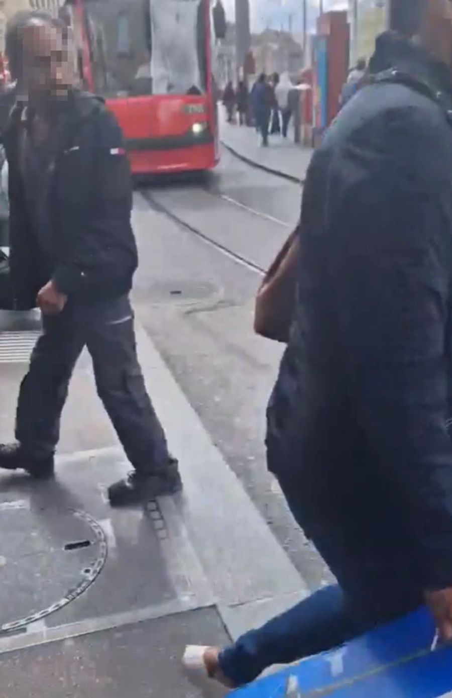 Nur wenige Meter vor dem Tram huschen Fussgänger vorbei.