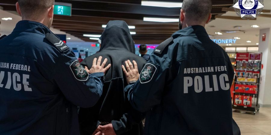 Polizisten führen den Schmuggler ab.