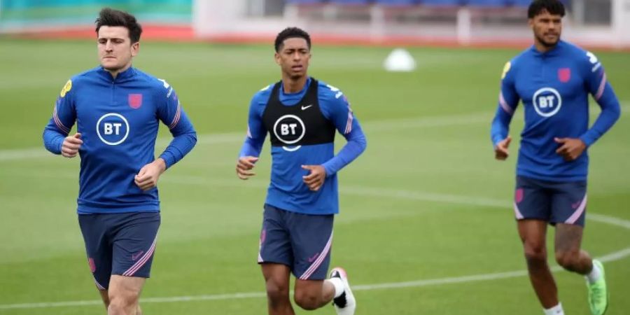 Harry Maguire (l-r) läuft sich mit Jude Bellingham und Tyrone Mings beim Training warm. Foto: Nick Potts/PA Wire/dpa