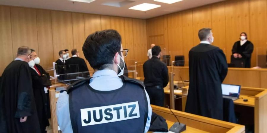 Der ehemalige Bundesligaprofi Deniz Naki (4.v.r.) steht im Landgericht hinter der Anklagebank. Foto: Marius Becker/dpa