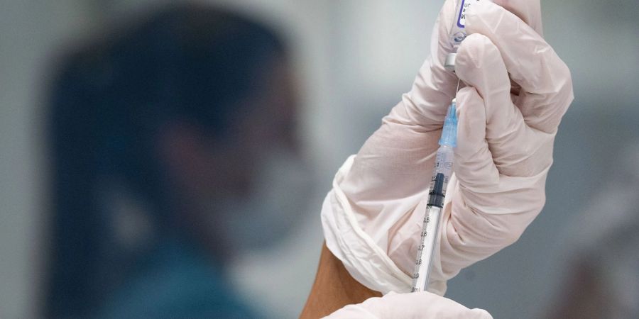 Eine Frau zieht eine Dosis des Impfstoffes von Biontech/Pfizer für eine Corona-Impfung auf. (Archivbild)
