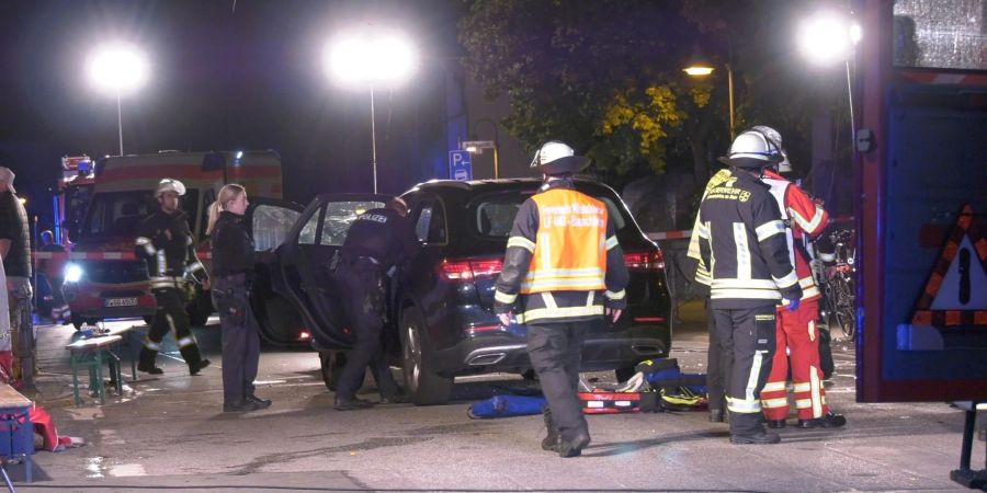 Einsatzkräfte der Polizei und Feuerwehr, sowie Rettungskräfte stehen im Rüsselsheimer Ortsteil Bauschheim an einer Unfallstelle.