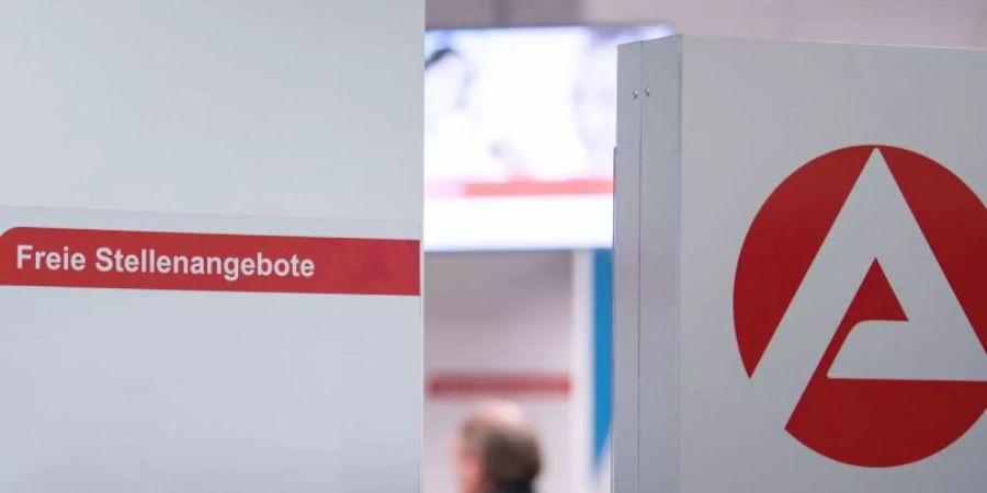 Ein Mann im Wartebereich hinter einer Stellwand für Stellenangebote in Stuttgart. Foto: Sebastian Gollnow/dpa