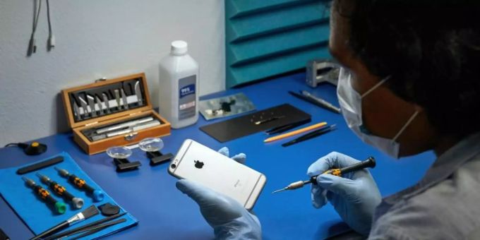 Ein Service-Techniker arbeitet an einem iPhone. Foto: Apple/dpa apple iphones