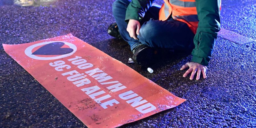 Ein Aktivist hat sich mit einer Hand auf einer Strasse festgeklebt. Aktivisten der «Letzten Generation» blockierten in Ludwigsburg im Berufsverkehr eine Durchgangsstrasse.