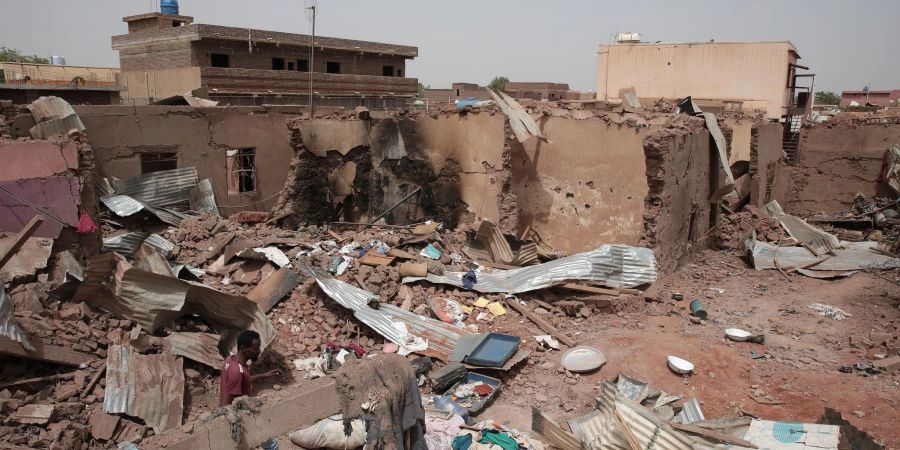 Ein Mann geht an einem Haus in Khartum vorbei, das bei den Kämpfen im Sudan getroffen wurde.