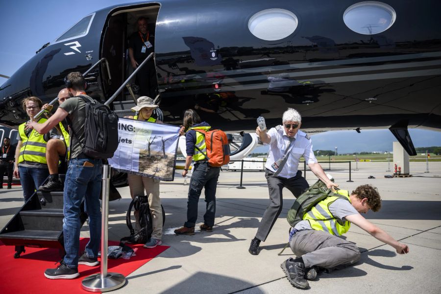 Die Aktivisten haben sich an Privatjets gekettet.