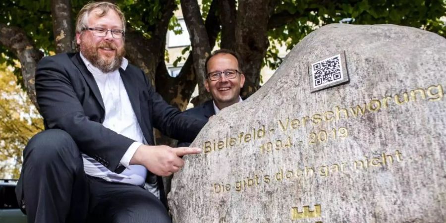 Martin Knabenreich (r), Geschäftsführer Bielefeld Marketing und Achim Held (l), Schöpfer der Bielefeld-Verschwörung, neben dem Denkmal. Foto: David Inderlied