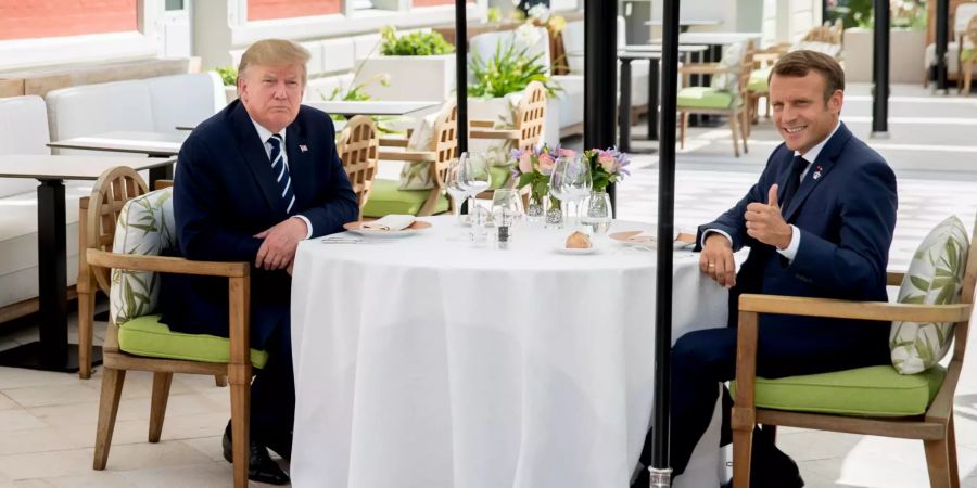 Donald Trump (l), Präsident der USA, und Emmanuel Macron, Präsident von Frankreich, unterhalten sich während eines gemeinsamen Mittagessens.