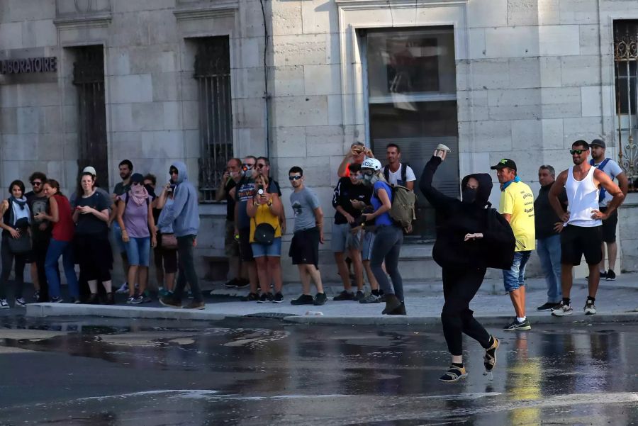 Ein Demonstrant wirft einen Stein in Richtung Polizei.