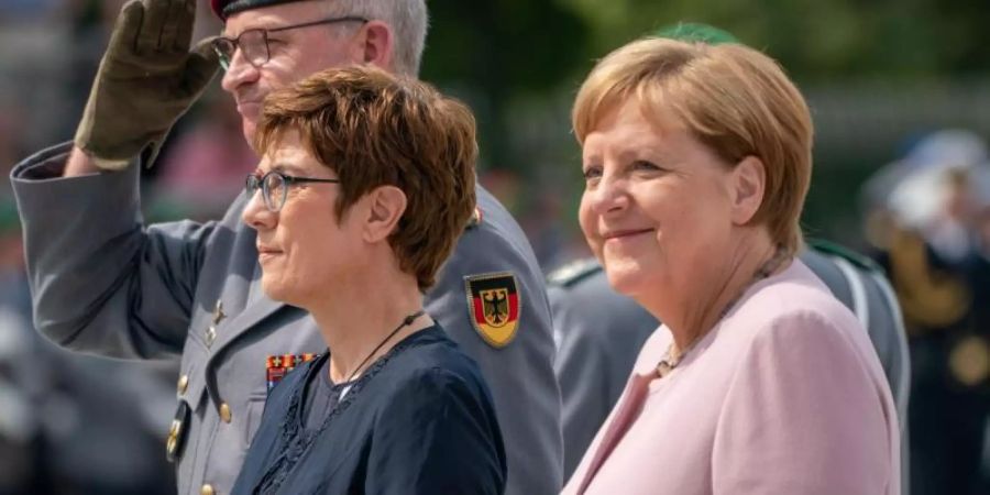 Bundesverteidigungsministerin Annegret Kramp-Karrenbauer und Bundeskanzlerin Angela Merkel beim Rekruten-Gelöbnis im Bendlerblock. Foto: Michael Kappeler