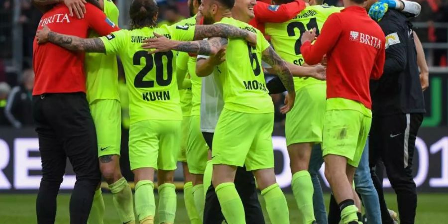 Geschafft: Die Spieler vom SV Wehen Wiesbaden feiern den Zweitliga-Aufstieg. Foto: Armin Weigel